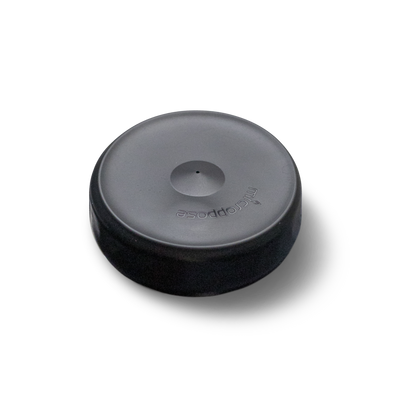 An isolated image of a black Microppose silicone jar cover with a single central hole, displayed against a white background for clear visibility.